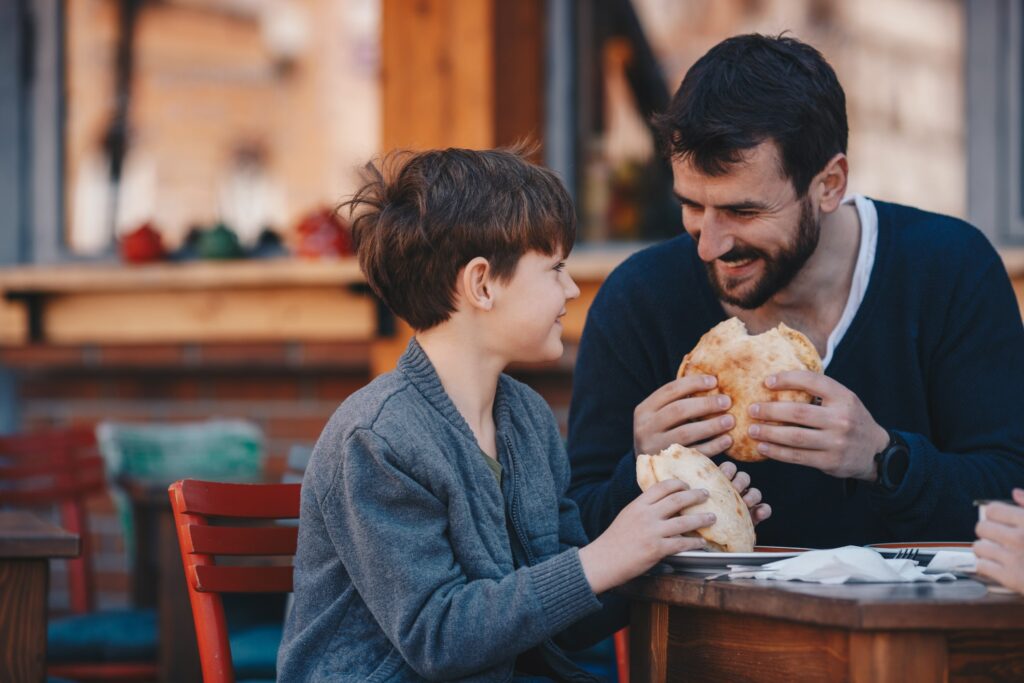 boy eating at restaurant with dad