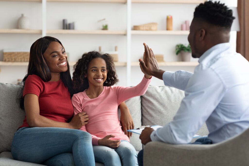 girl with mom high fiving man